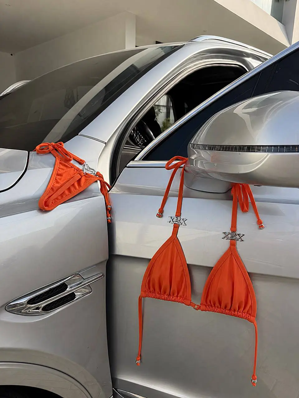 Orange Vonne X2X bikini styled against a silver car